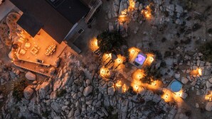 An aerial view of a property with a patio area, outdoor seating, and a swimming pool. - Desert Nest: Cozy Retreat Amidst Boulders (Yucca Valley)