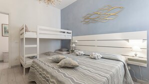 A bedroom with a bunk bed, a bedside table with a lamp, and a wall-mounted shelf. - Casa Liliana Ac Wifi Forte Dei Marmi (Forte dei Marmi)