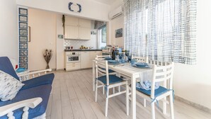 A modern kitchen with white cabinets, a dining table set for four, and a blue and white checkered curtain. - Casa Liliana Ac Wifi Forte Dei Marmi (Forte dei Marmi)
