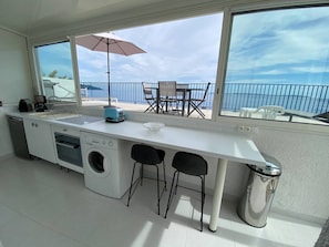 Enjoy a meal in the dining area, then relax on the balcony with a view of the sea.