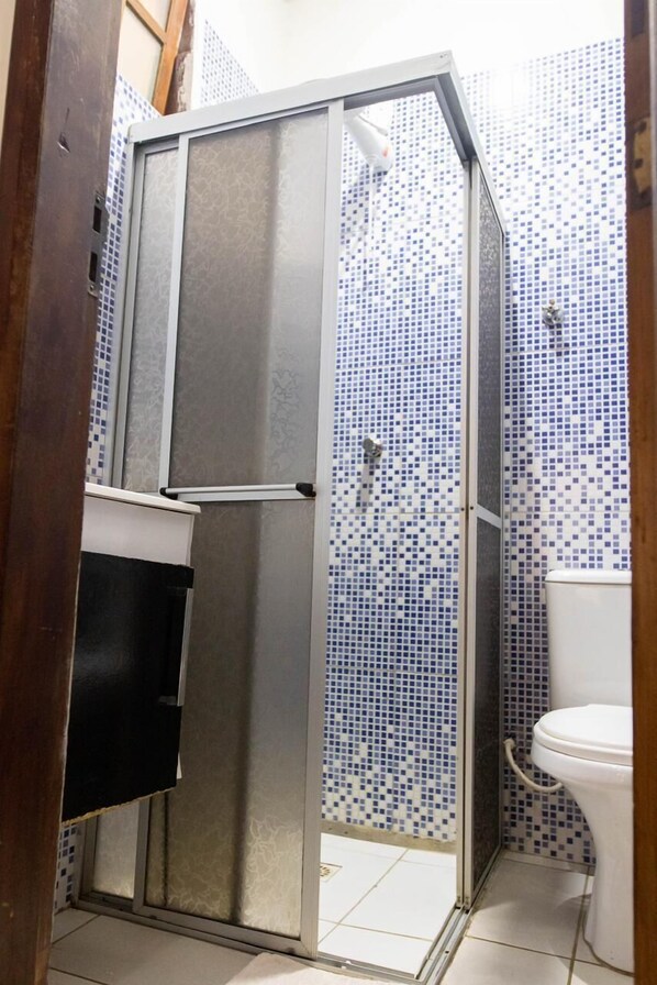 A bathroom with a shower enclosure, a toilet, and a sink. - Pousada Pura Vida (Itacaré)