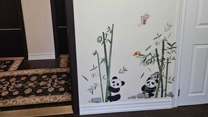A hallway with a dark wooden floor, a patterned rug, and a white door. - Room-double Room 2 Brampton Toronto Cana (Brampton)