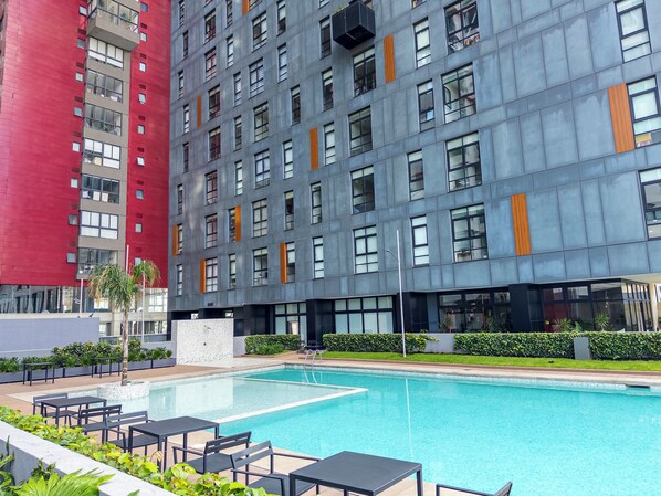 Un edificio moderno con piscina y zona de estar al aire libre.