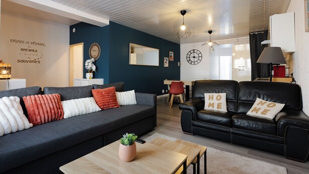 A modern living room with a dark grey sofa, a black leather sofa, and a wooden coffee table. - Le reflet des Pyrénées 6/8 people, close to town center and ski shuttles (Bagnères-de-Bigorre)
