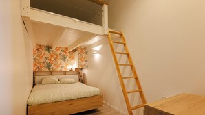 A bunk bed with a wooden ladder, a small table, and a wall with a floral wallpaper. - Le reflet des Pyrénées 6/8 people, close to town center and ski shuttles (Bagnères-de-Bigorre)