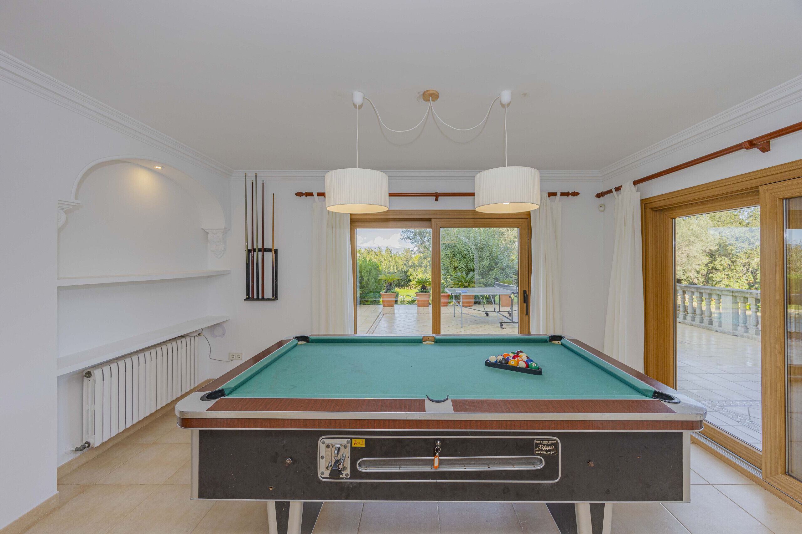 Une table de billard avec vue sur un balcon et un espace extérieur.