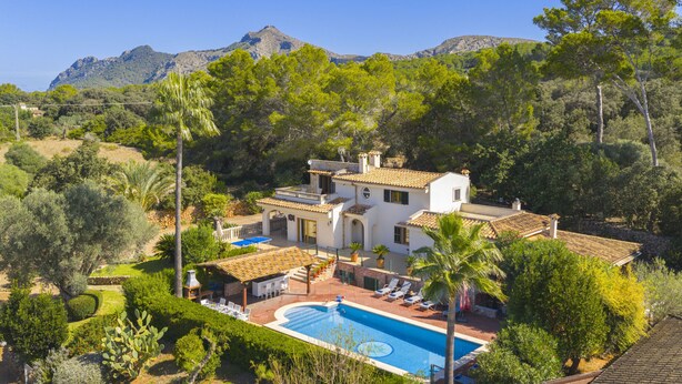 A villa with a pool, surrounded by lush greenery and mountains in the background. - Villa Can Emmes (Alcúdia)