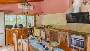 A kitchen with wooden cabinets, a microwave, a sink, and a built-in oven. - Villa Can Emmes (Alcúdia)