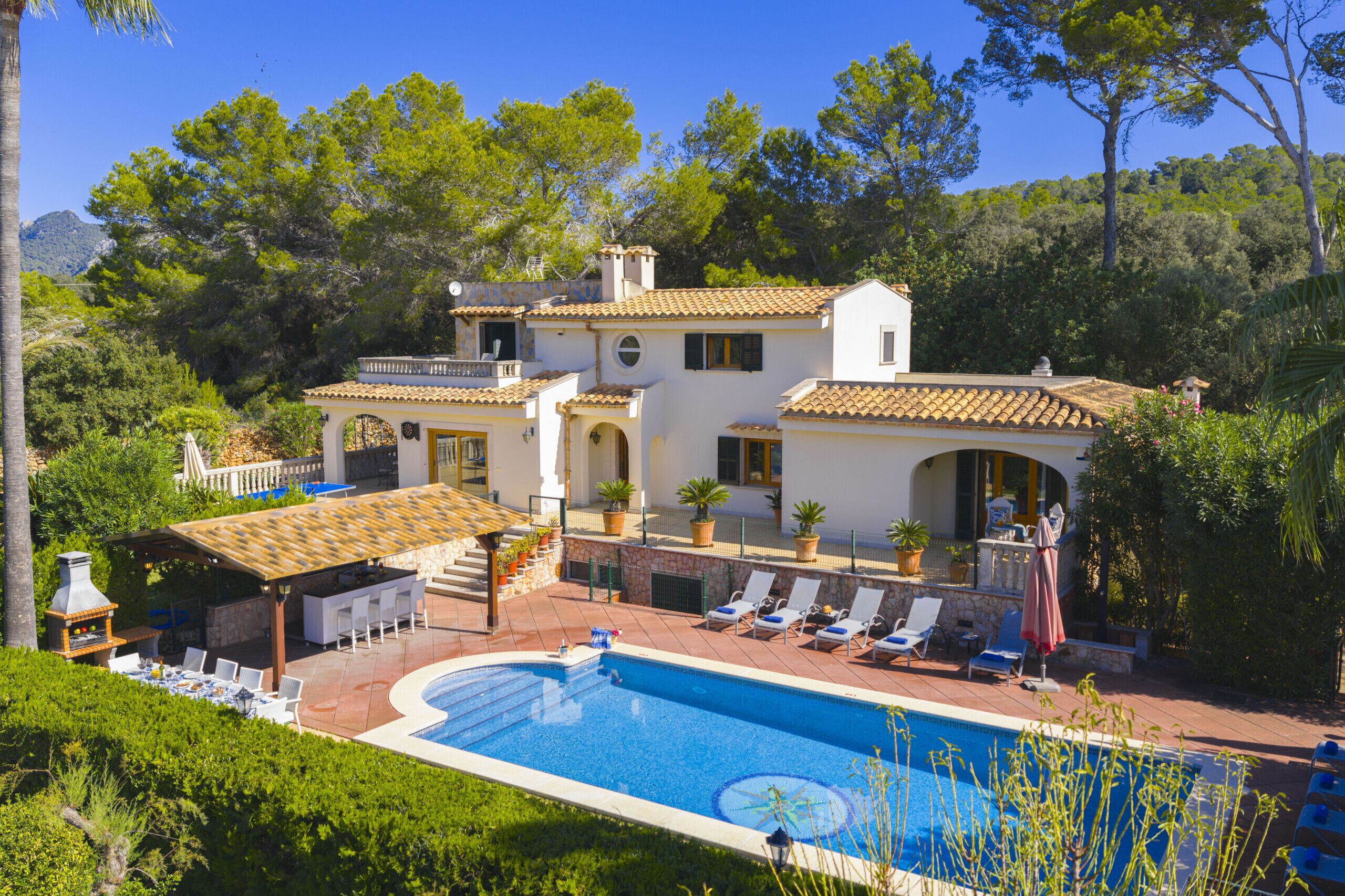 Uma villa com piscina, área de estar ao ar livre e um pátio.