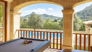 A pool table with a view of a mountain and a pool.