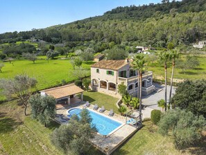 Une villa dotée d’une piscine, d’un espace extérieur aménagé et offrant une vue sur la campagne environnante.