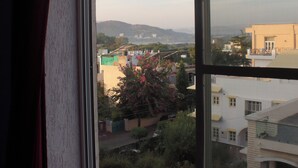 Una ventana con vistas a un área residencial, con edificios y zonas verdes.