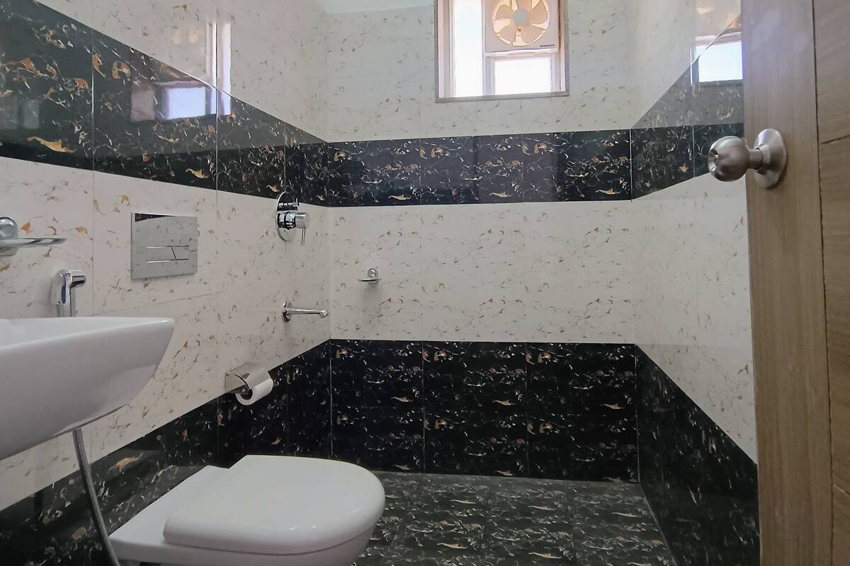A bathroom with a toilet, sink, and shower.