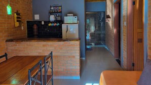 Une cuisine moderne avec un mur en briques, un plafond en bois et un coin repas comprenant une table et des chaises en bois.