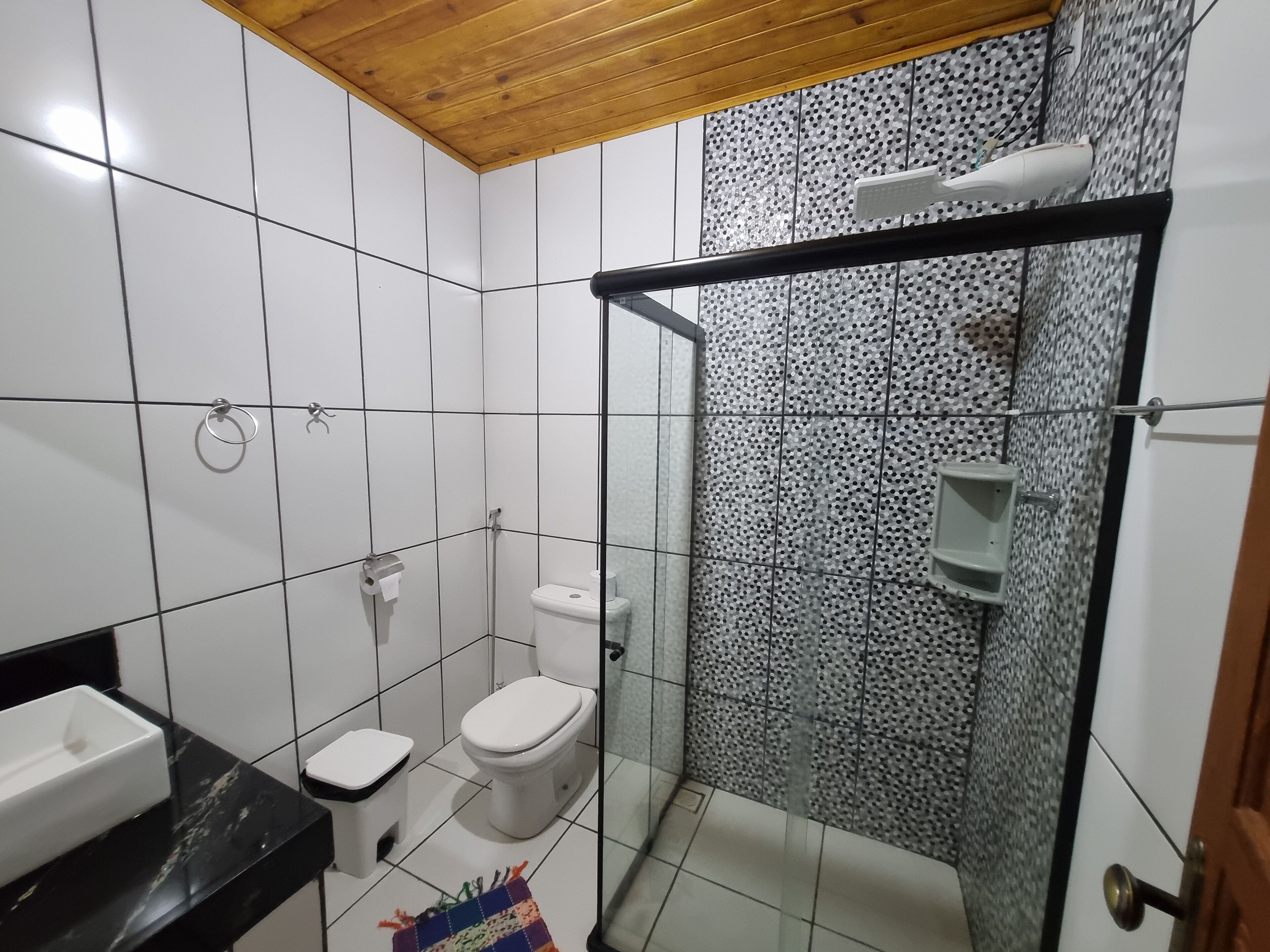 Baño con inodoro, bidé y cabina de ducha de vidrio.