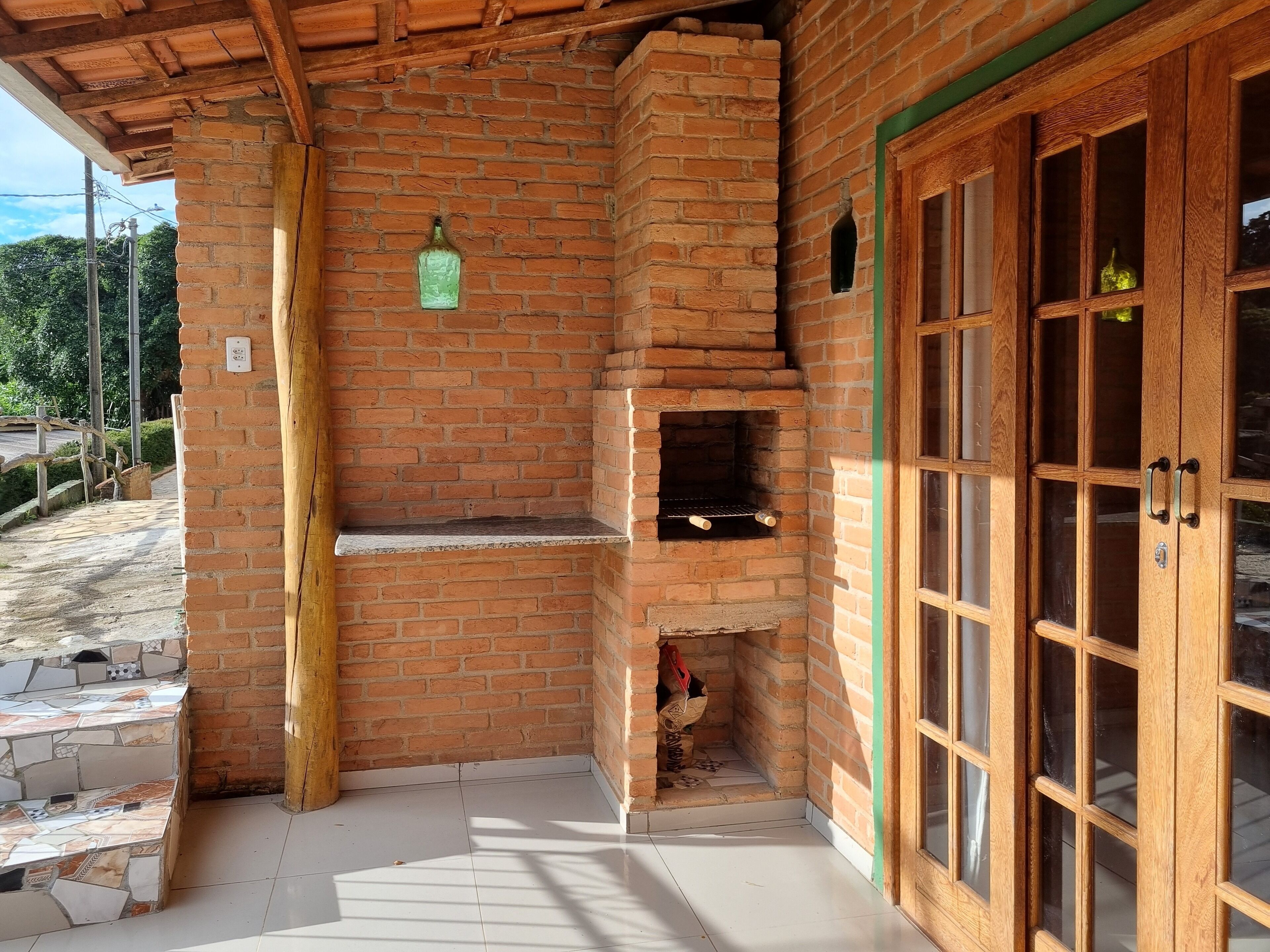 Un espacio al aire libre de ladrillo con una puerta de madera y un horno de leña.