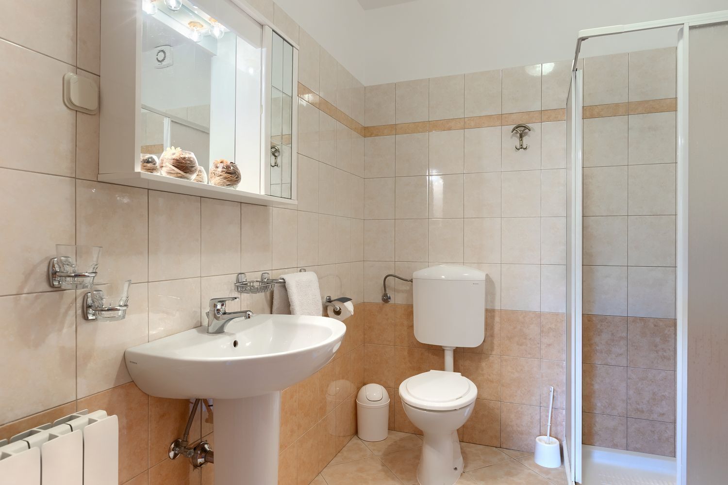 Une salle de bain avec un lavabo, des toilettes et une douche.