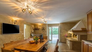 A spacious kitchen with a large wooden table, built-in cabinets, and a modern chandelier.