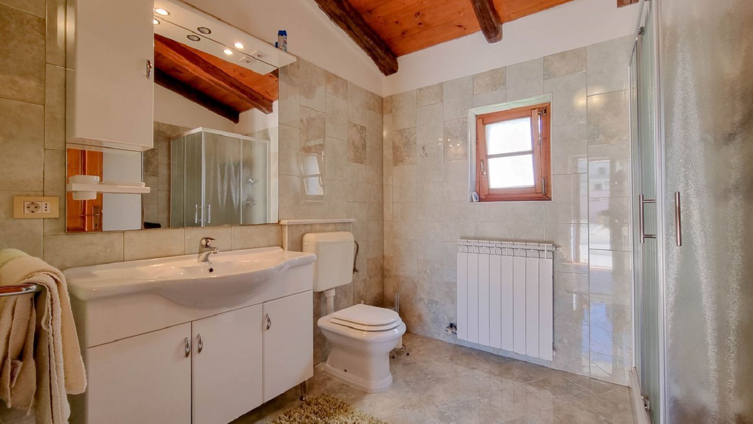 Un baño con lavamanos, inodoro y ventana.