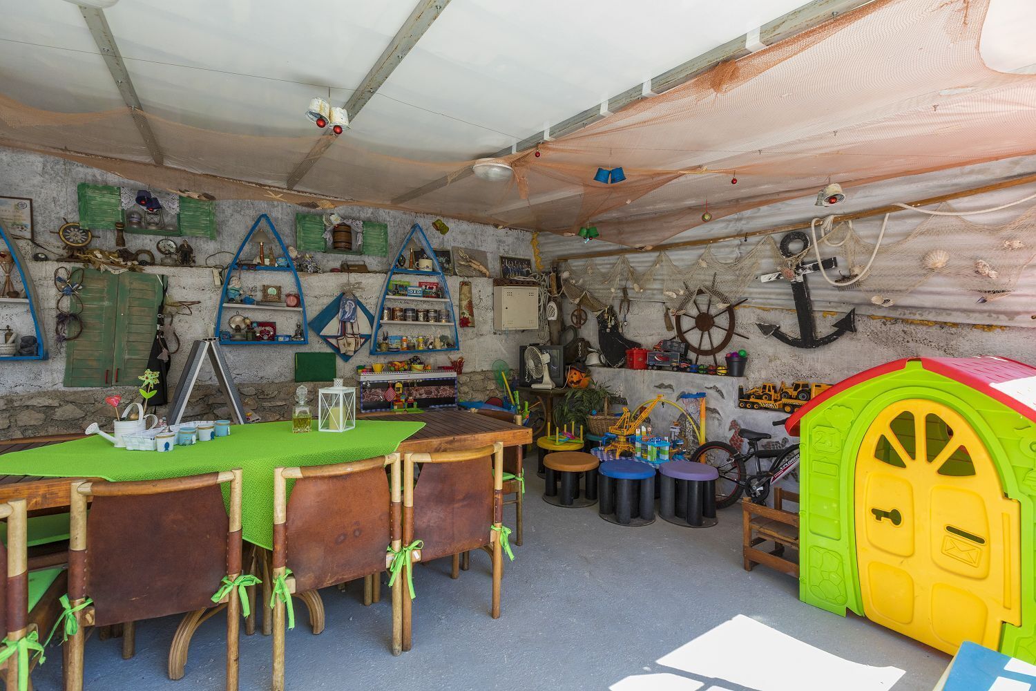 A rustic room with a wooden table, chairs, and a green door.