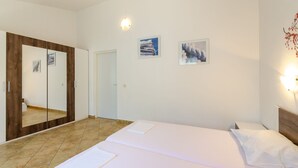Una habitación de hotel con una cama, un espejo grande y dos cuadros en la pared.