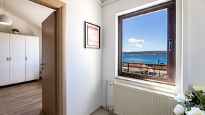 A room with a view of the sea, a radiator, and a white cabinet.