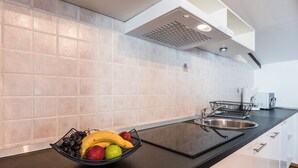 A modern kitchen with a black countertop, a stainless steel sink, and a fruit bowl containing bananas, apples, and grapes. - Impressive flat just 500 metres from the beach with sea views, flat-screen TV on the balcony, BBQ (Dramalj)