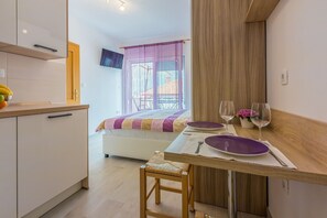 Enjoy a simple yet elegant dining experience in this cozy room, featuring a kitchenette, comfortable bed, and warm atmosphere.