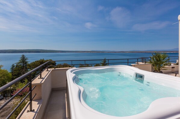 Relax in a tranquil hot tub with breathtaking ocean views from a spacious balcony.