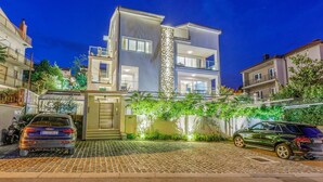 A modern two-story house with a gated entrance, a balcony, and a driveway with parked cars. - Impressive flat just 500 metres from the beach with sea views, sauna, gym, pool (Crikvenica)