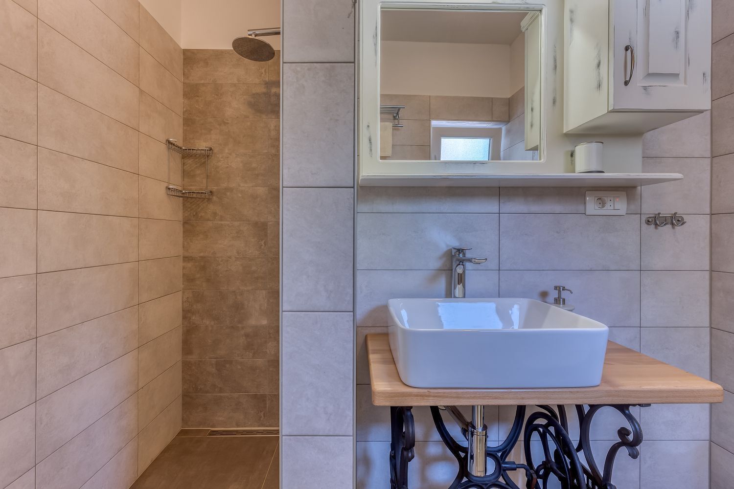 A bathroom with a shower, a sink, and a mirror.