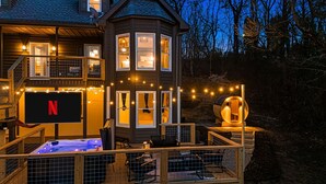 Et toetagers hus med terrasse, jacuzzi og en stor, rund lampe.