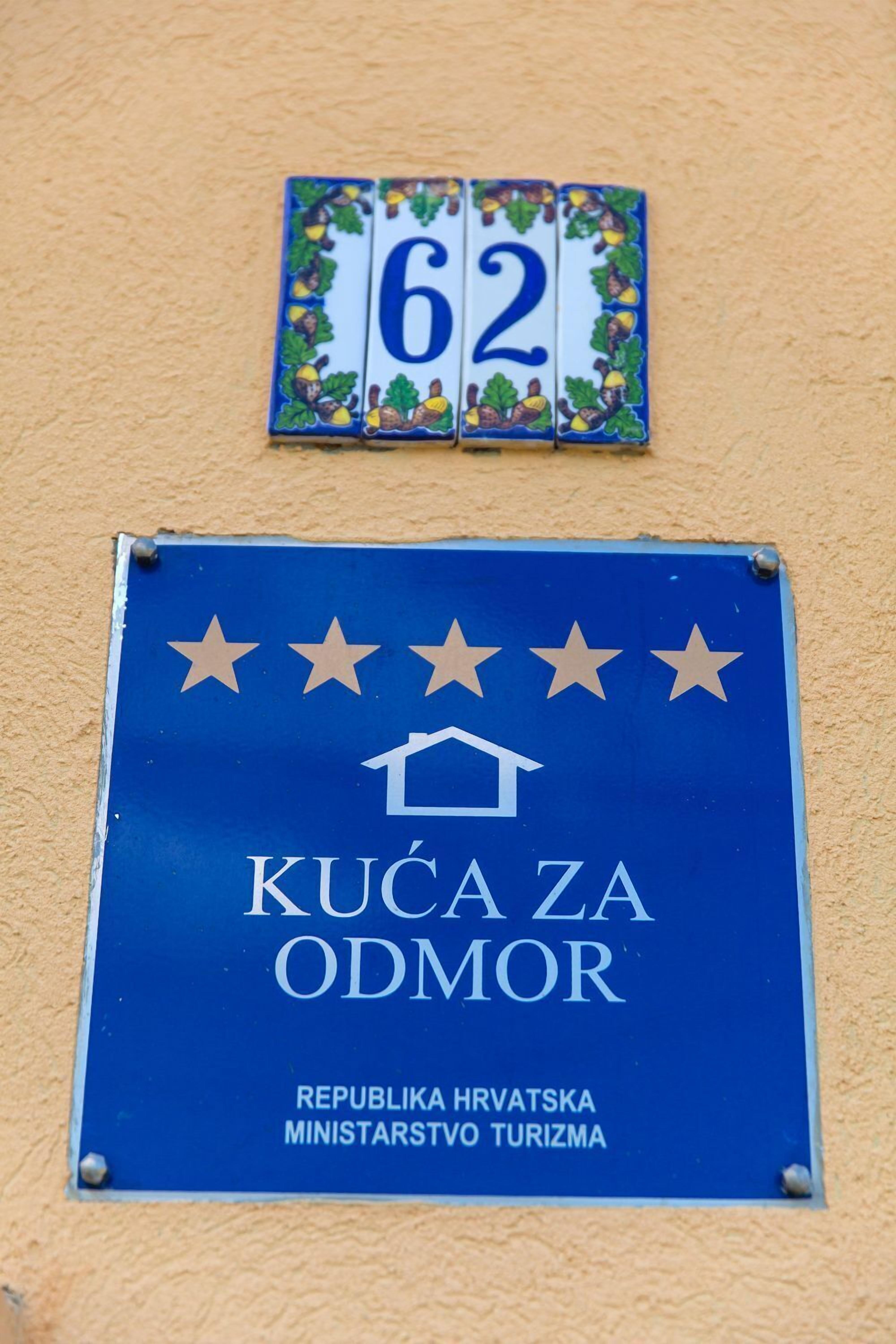 A sign with the text "KUČA ZA ODNOR" and "REPUBLICA HRVATSKA MINISTARSTVO TURIZMA" indicating a tourism office in Croatia.