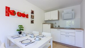 Une cuisine moderne avec des armoires blanches, un four encastré et un four à micro-ondes.