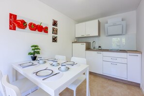 Enjoy meals and relaxation in this well-appointed kitchen and dining area, featuring an oven, microwave, and comfortable seating for four.