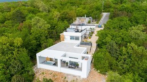 Una casa moderna amb teulada plana, finestres grans i zona de pati.