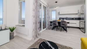 A modern apartment with a dining area, kitchen, and a balcony with a view. - Light-flooded flat with sea view, private balcony, WiFi, private car park (Crikvenica)