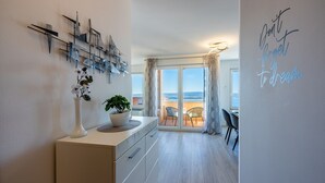 A modern kitchen with a view to the sea, a dining area with a view, and a motivational quote on the wall. - Light-flooded flat with sea view, private balcony, WiFi, private car park (Crikvenica)