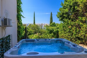 Un jacuzzi en un jardín con vistas a montañas.