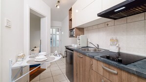 Una cocina moderna con horno empotrado, un lavamanos de acero inoxidable y armarios de madera.