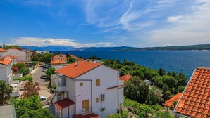 A coastal residential area with terracotta-roofed houses, a clear blue sky, and a view of the sea. - Stunning flat 150 metres to the beach with jacuzzi, sea view, pool, pool table (Dramalj)