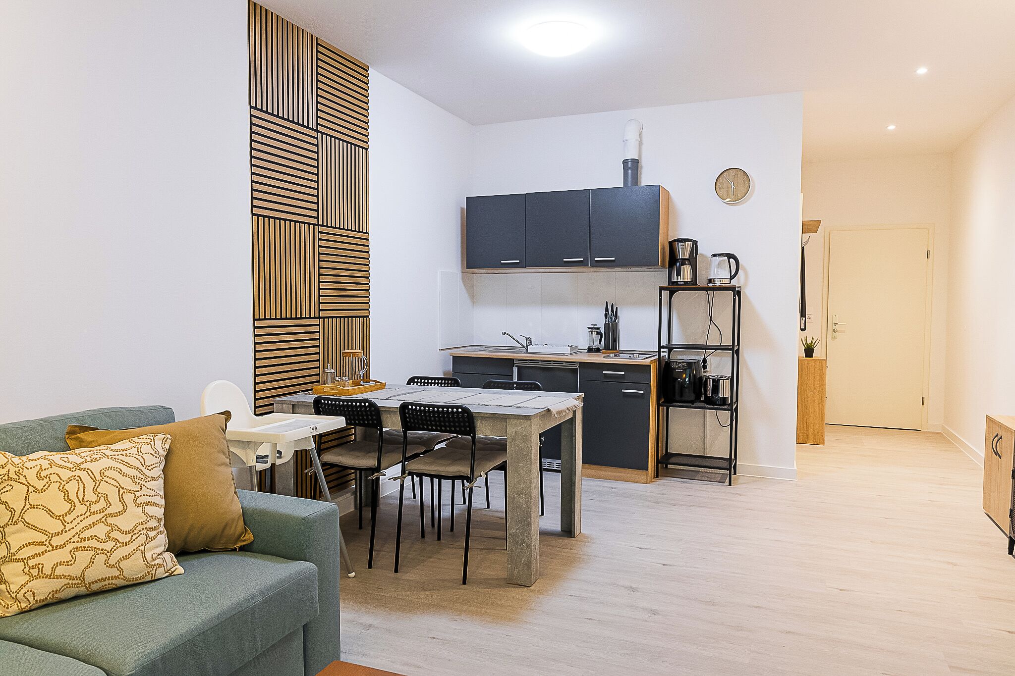 A compact living space with a kitchenette, a dining area, and a sofa.