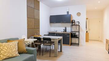 A compact living space with a kitchenette, a dining area, and a sofa.