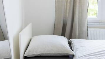 Ein ordentlich eingerichtetes Schlafzimmer mit Bett, Nachttisch und einem Wandbild.