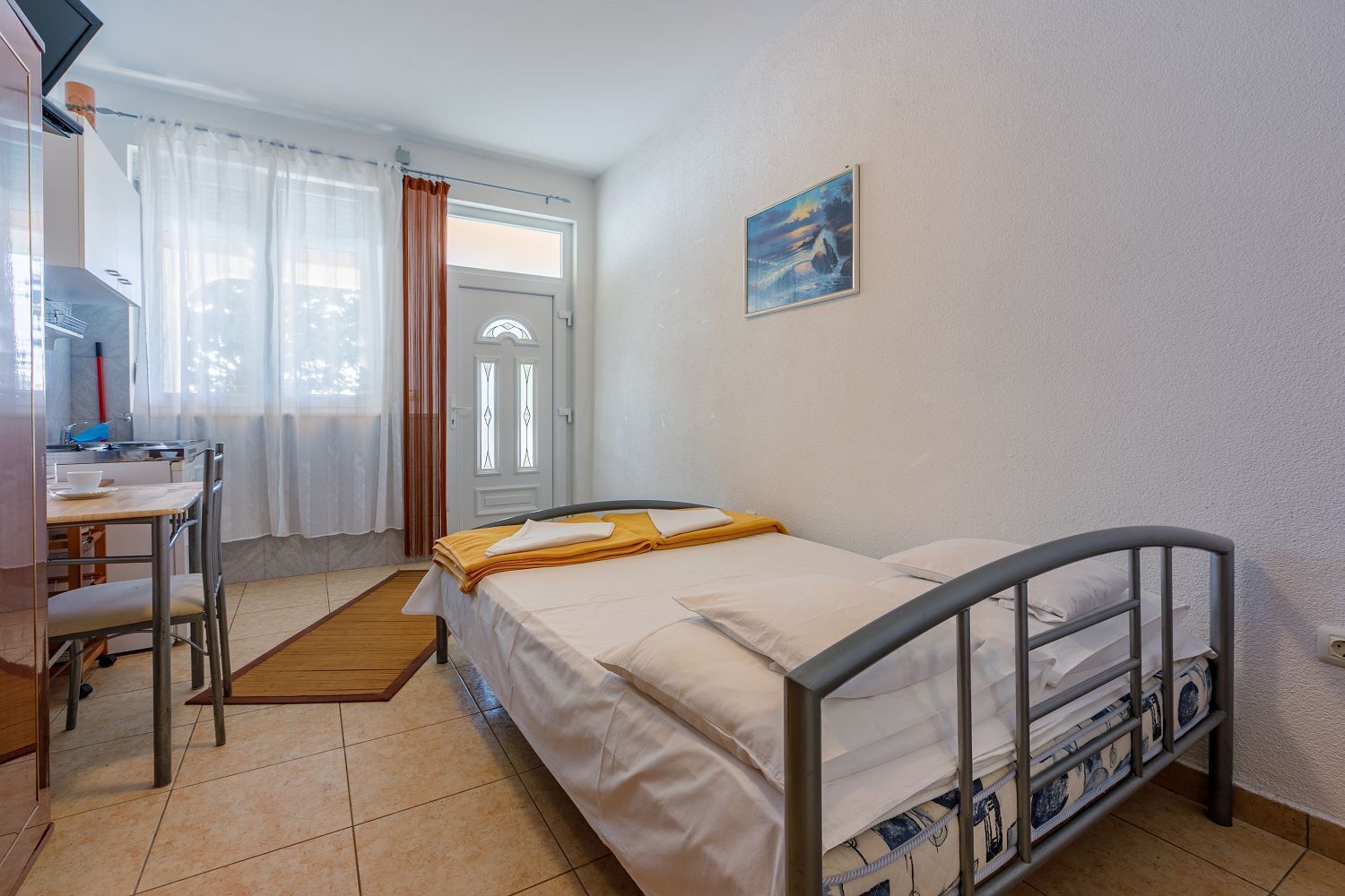 Een slaapkamer met een bed, een bureau en een stoel.