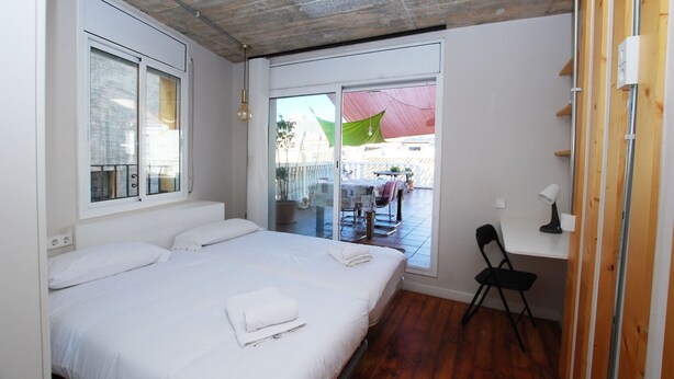 A bedroom with a large bed, a desk, and a chair. - Masnou Chill - Penthouse Terrace in front of the Beach (El Masnou)