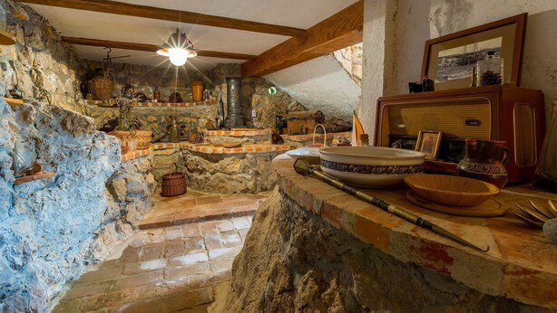 A rustic kitchen with stone walls, wooden beams, and a variety of kitchenware and utensils. - Fantastic flat with its own wine cellar, hydromassage shower, sea view - only 480 metres to the beach (Crikvenica)