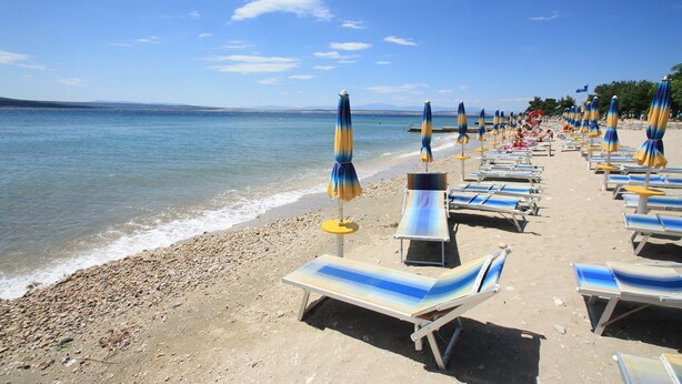 A beach with rows of sun loungers and umbrellas, a clear sky, and calm sea. - Idyllic flat just 400 metres from the sandy beach with sea views, WiFi and private parking (Crikvenica)
