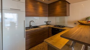 A modern kitchen with wooden cabinets, a stainless steel sink, and a gas stove. - Unique flat with magnificent sea views, pool, BBQ and only 700 metres to the beach (Crikvenica)