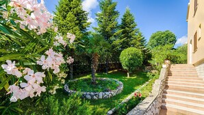 Un jardin avec un chemin de pierres menant à un bâtiment.